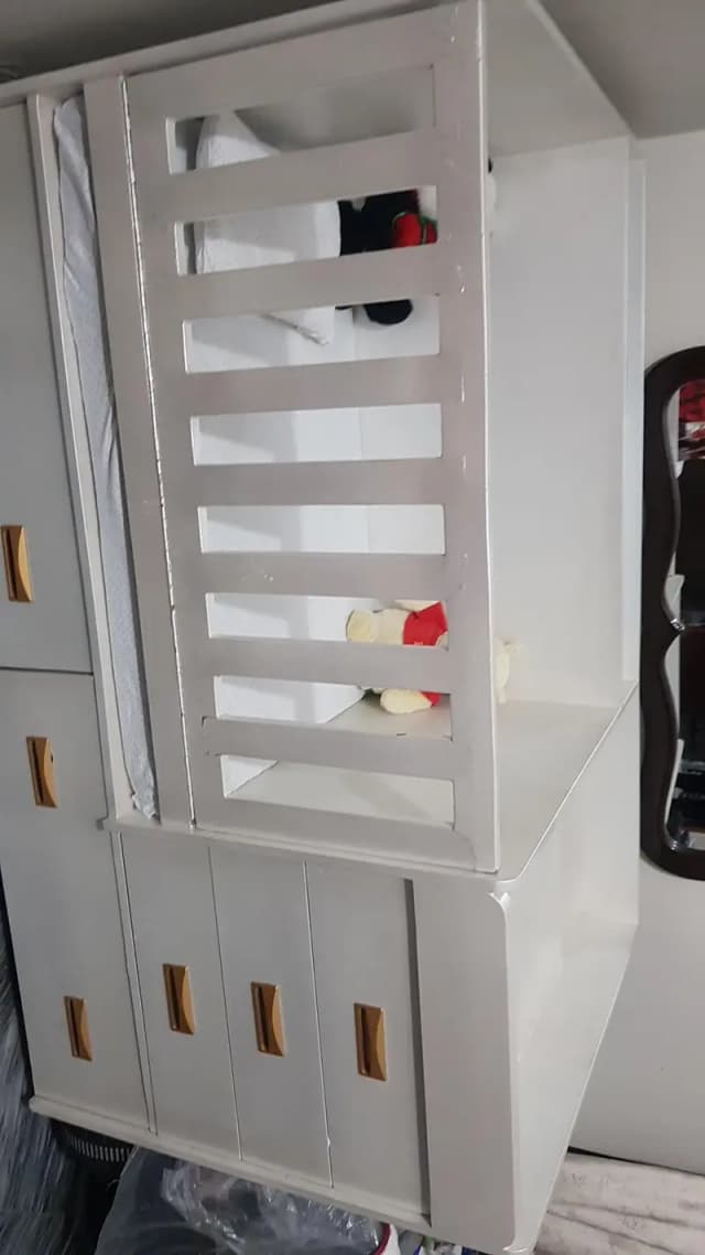white baby crib with 7 draws in it